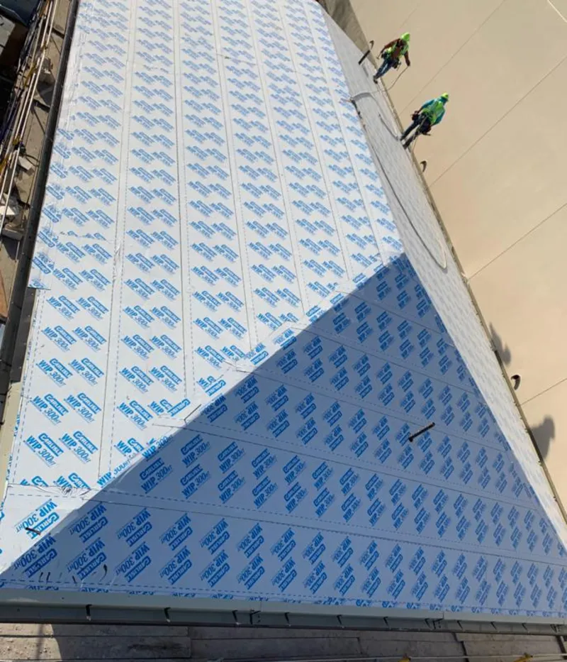 Professional roofers installing underlayment on a metal roof in Moreno Valley